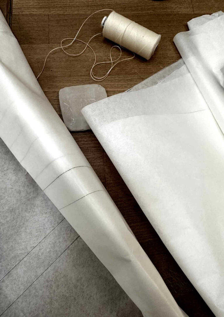 Detalje af silke, spor og rå naturmaterialer i værket